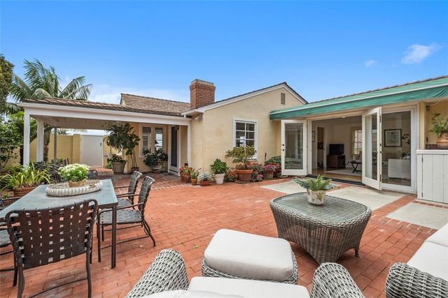 a view of a patio with couches table and chairs and potted plants