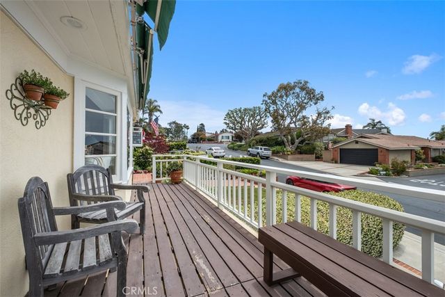 a balcony with wooden floor table and chairs
