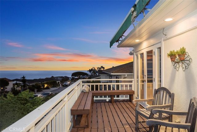 a view of a balcony with wooden floor and outdoor seating