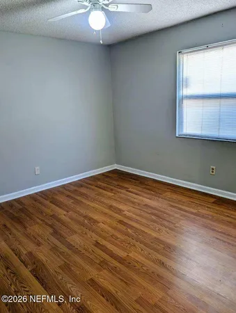 a view of a room with wooden floor and white walls