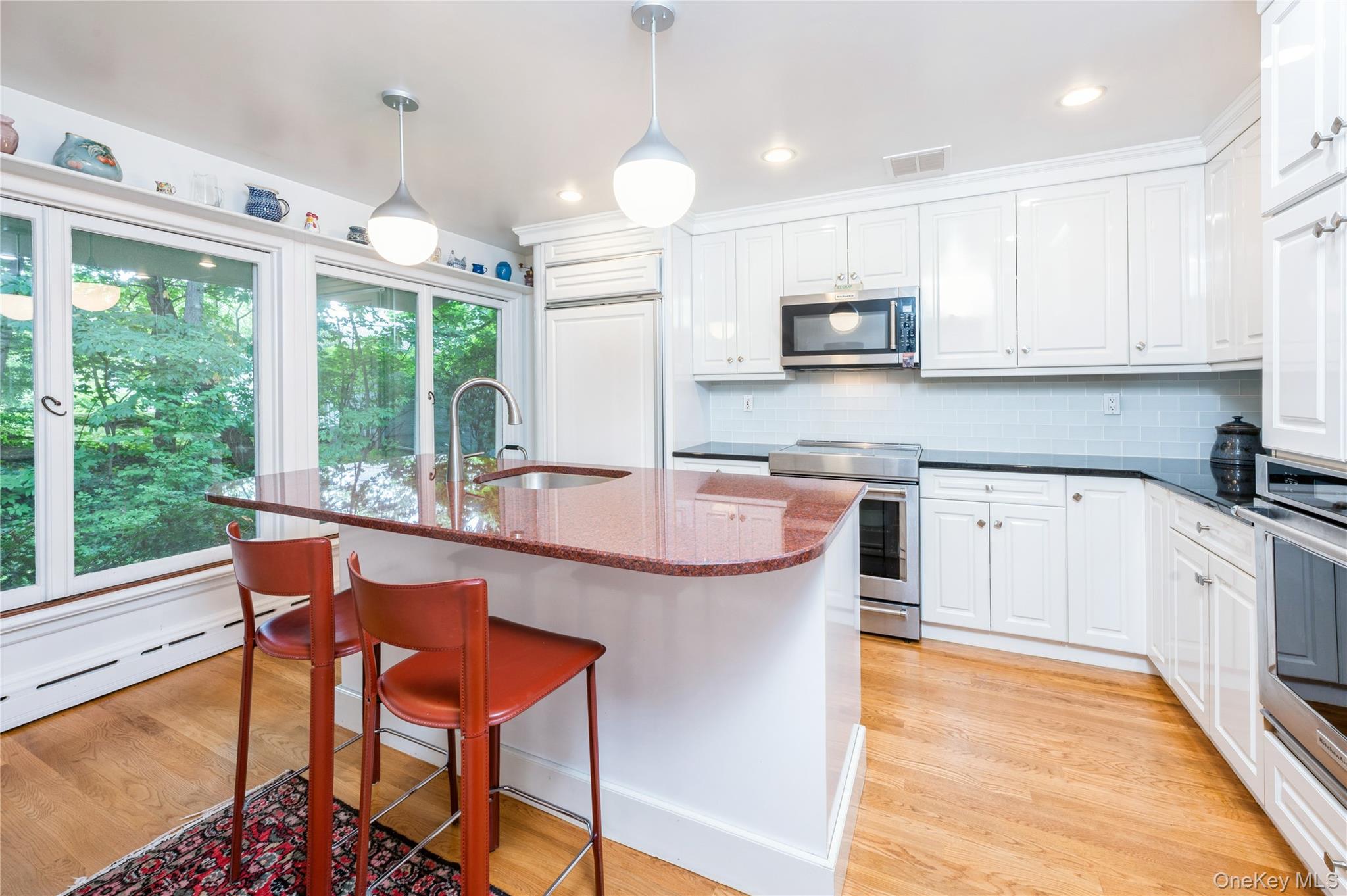 160 Hampshire Road Bronxville, NY 10708 - Photo 16 of 36 a kitchen with stainless steel appliances granite countertop a stove top oven a sink dishwasher a dining table and chairs with wooden floor