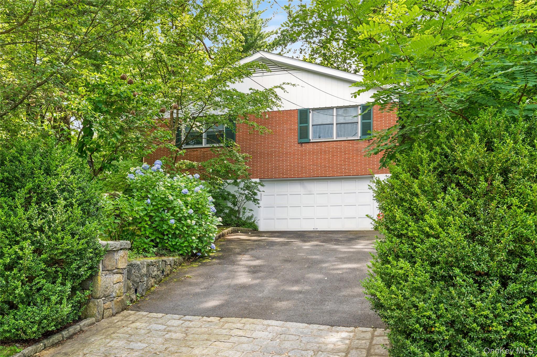160 Hampshire Road Bronxville, NY 10708 - Photo 33 of 36 a front view of a house with a yard and a garage