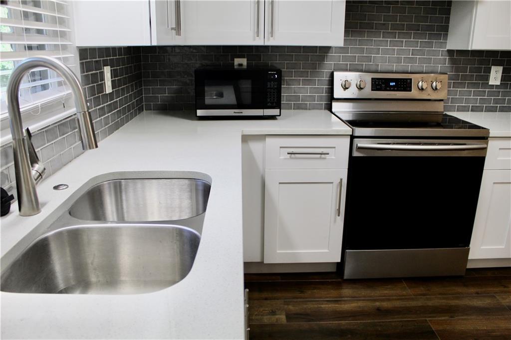 1191 Hampton Way Northeast Atlanta, GA 30324 - Photo 11 of 31 a kitchen with a stove and white cabinets
