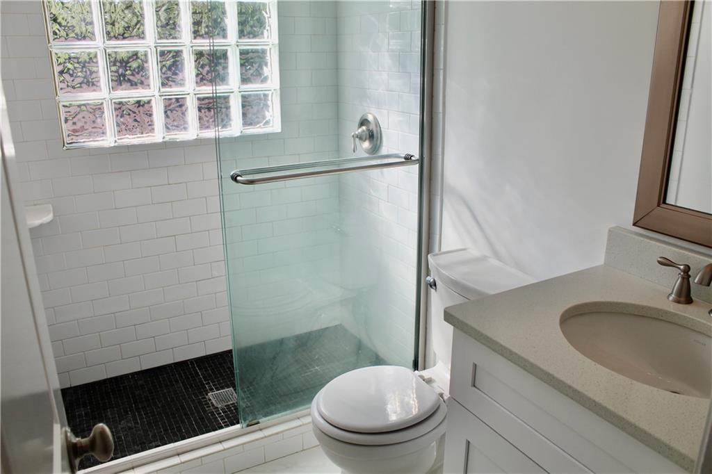1191 Hampton Way Northeast Atlanta, GA 30324 - Photo 25 of 31 a bathroom with a granite countertop toilet sink and mirror