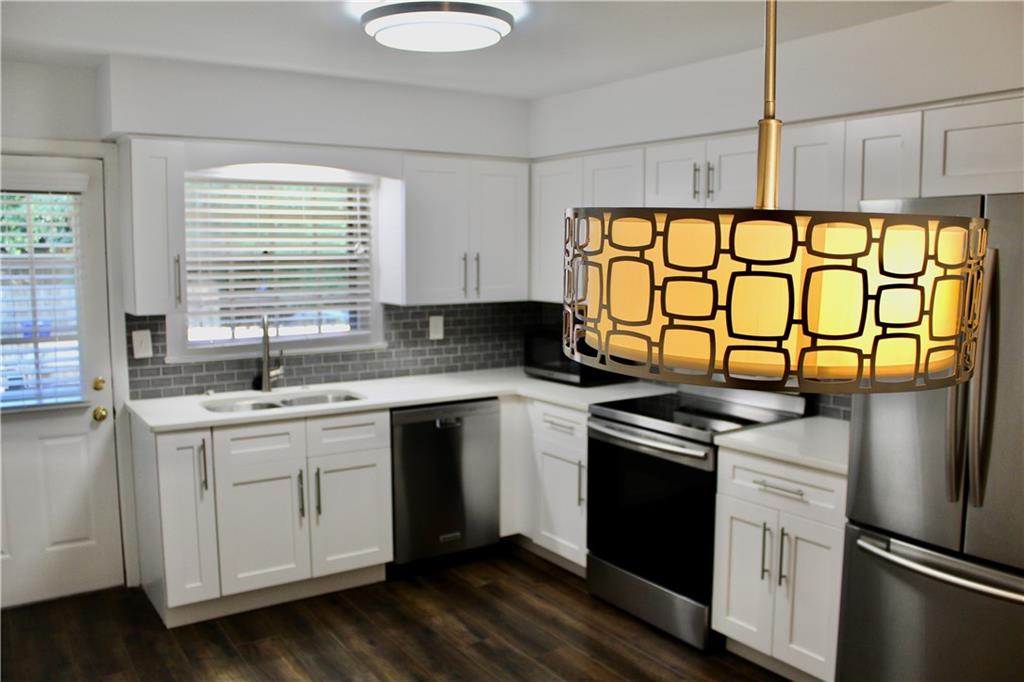 1191 Hampton Way Northeast Atlanta, GA 30324 - Photo 8 of 31 a kitchen with stainless steel appliances a sink cabinets and a window