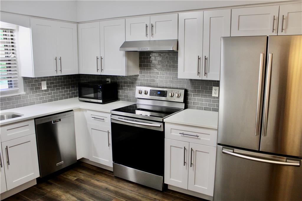 1191 Hampton Way Northeast Atlanta, GA 30324 - Photo 9 of 31 a kitchen with cabinets stainless steel appliances and wooden floor