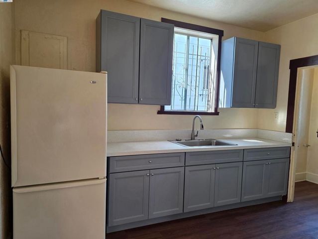 a kitchen with a sink a refrigerator and cabinets