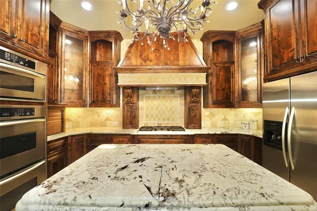 a view of a kitchen with granite countertop a sink and dishwasher stove a refrigerator with wooden floor