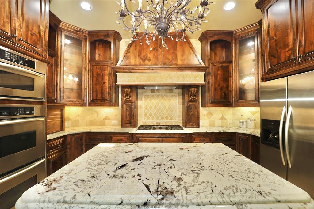 1609 Singletree Court McKinney, TX 75072 - Photo 12 of 38 a view of a kitchen with granite countertop a sink and dishwasher stove a refrigerator with wooden floor