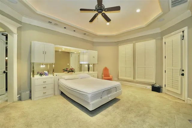 a spacious bedroom with a bed and a chandelier
