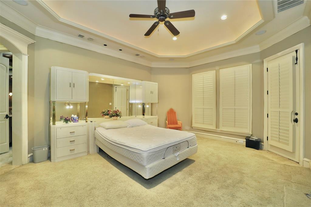 1609 Singletree Court McKinney, TX 75072 - Photo 15 of 38 a spacious bedroom with a bed and a chandelier