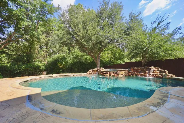 a view of a swimming pool with lawn chairs and a fire pit