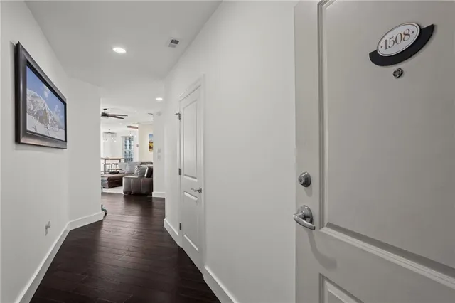 a view of a hallway with a view of a hallway with wooden floor and closet