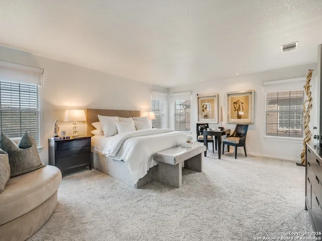 a spacious bedroom with a bed and a couch