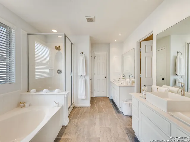 a bathroom with a bathtub shower and a sink