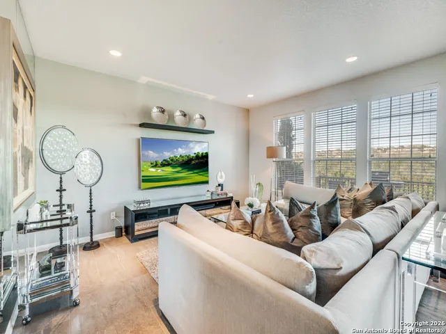 a living room with furniture a large window and flat screen tv