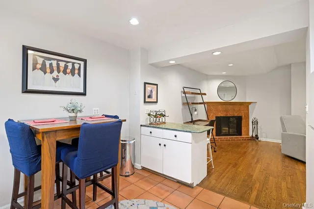 a view of a dining room with furniture a fireplace and wooden floor