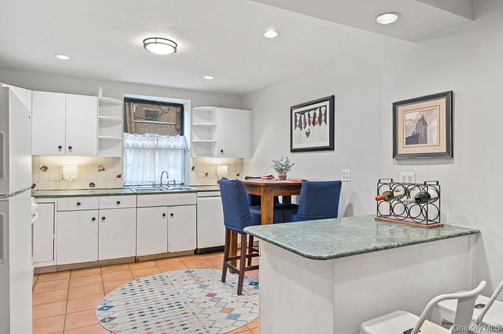 914 Wynnewood Road, Unit LL4 Pelham, NY 10803 - Photo 10 of 22 a kitchen with granite countertop sink stove and white cabinets