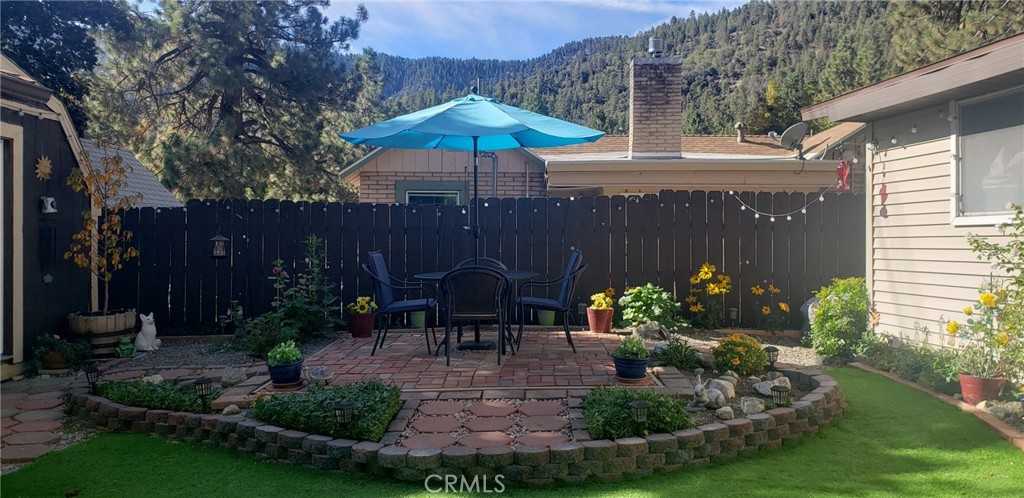965 Snowbird Road Wrightwood, CA 92397 - Photo 24 of 28 a view of a chair and table under an umbrella in patio