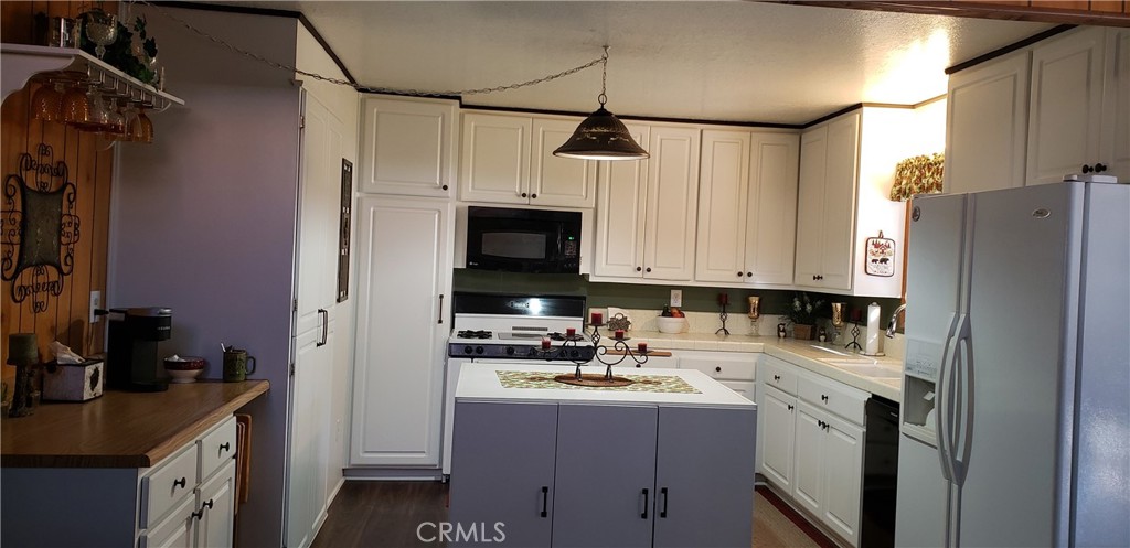 965 Snowbird Road Wrightwood, CA 92397 - Photo 9 of 28 a kitchen with a sink a refrigerator and cabinets