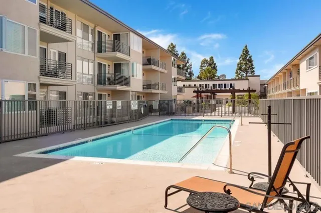 a view of backyard with swimming pool and furniture