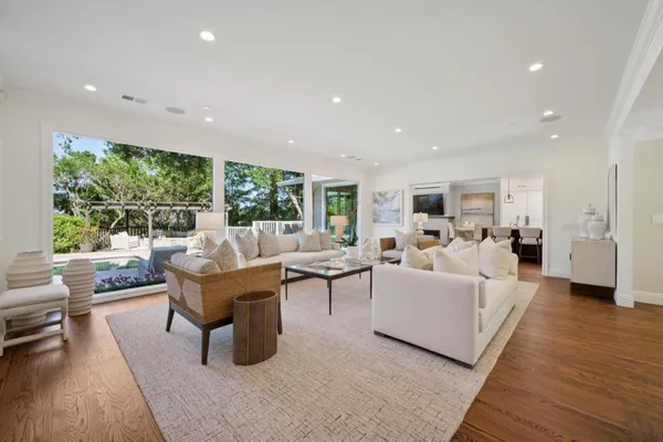 a living room with furniture floor to ceiling window and wooden floor