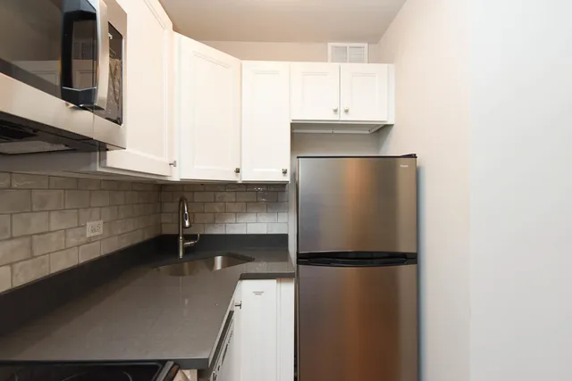 a kitchen with a refrigerator and a sink