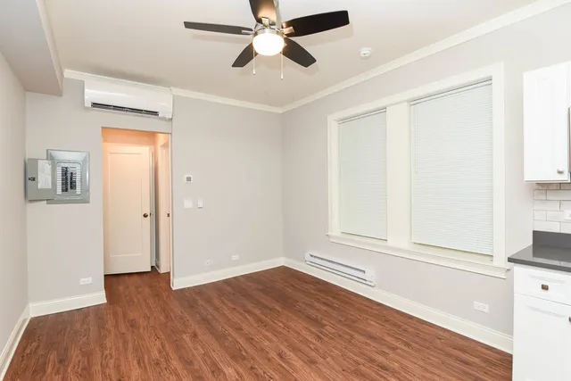 a view of empty room with wooden floor and fan