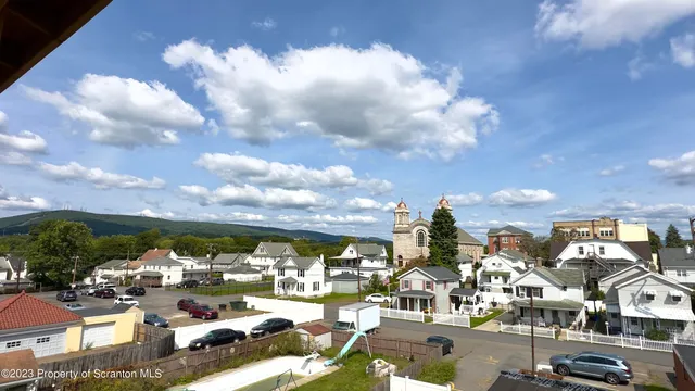 a view of a hallway with wooden floor and a living room