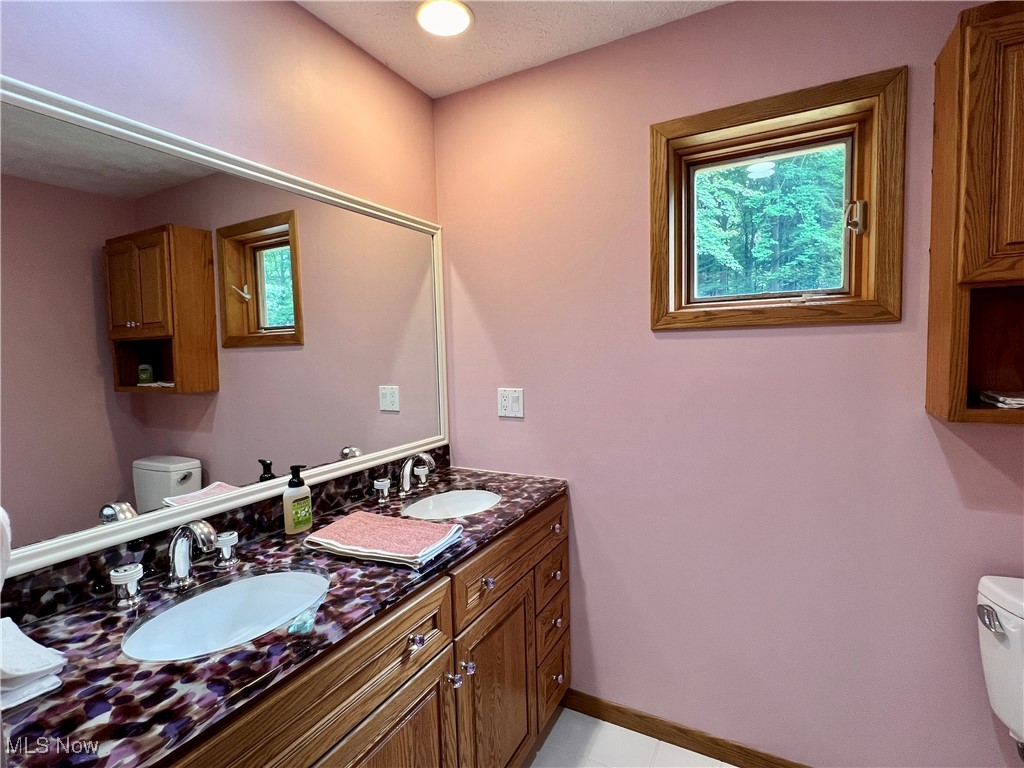 48632 Garfield Road Oberlin, OH 44074 - Photo 26 of 36 Bathroom featuring tile patterned floors, double vanity, and toilet