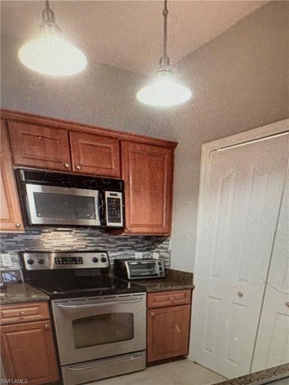 12970 Positano Circle, Unit 106 Naples, FL 34105 - Photo 3 of 5 a kitchen with stainless steel appliances granite countertop a stove and a microwave