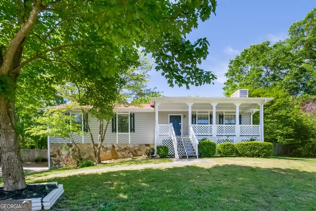 a front view of a house with a yard and green space