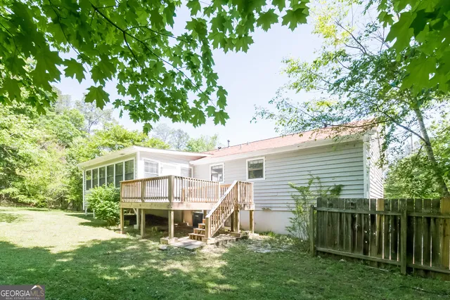 a view of a house with a yard chairs and a tree