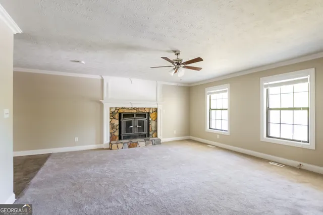 a view of an empty room with a fireplace and a window