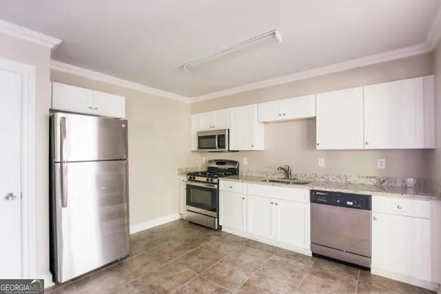 a kitchen with stainless steel appliances granite countertop a refrigerator sink stove and cabinets