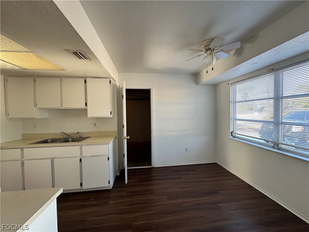 2429 George Avenue South, Unit 2431 Lehigh Acres, FL 33973 - Photo 3 of 16 a view of a kitchen with wooden floor and a sink