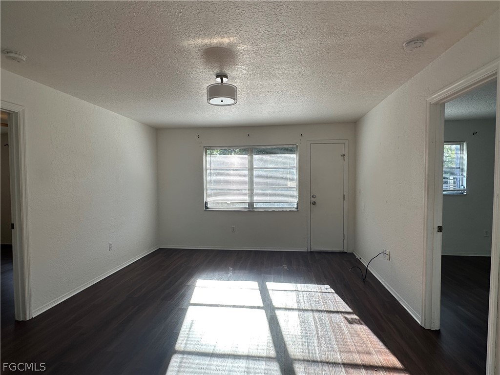 2429 George Avenue South, Unit 2431 Lehigh Acres, FL 33973 - Photo 7 of 16 an empty room with wooden floor and windows