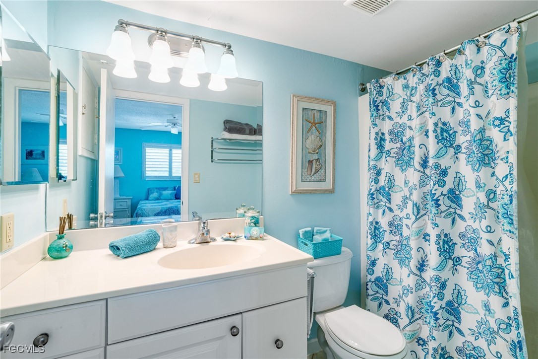 1549 Sandpiper Street, Unit 34 Naples, FL 34102 - Photo 11 of 15 a bathroom with a sink a toilet and shower curtain