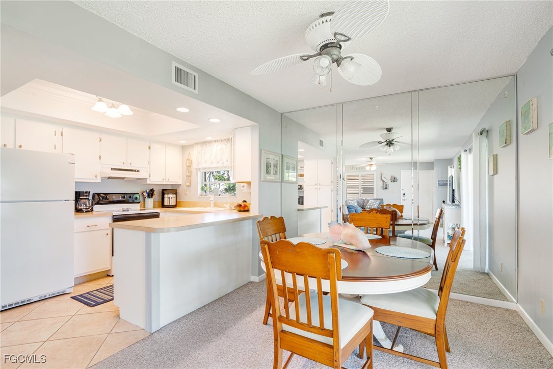 1549 Sandpiper Street, Unit 34 Naples, FL 34102 - Photo 5 of 15 a kitchen with a dining table chairs and refrigerator