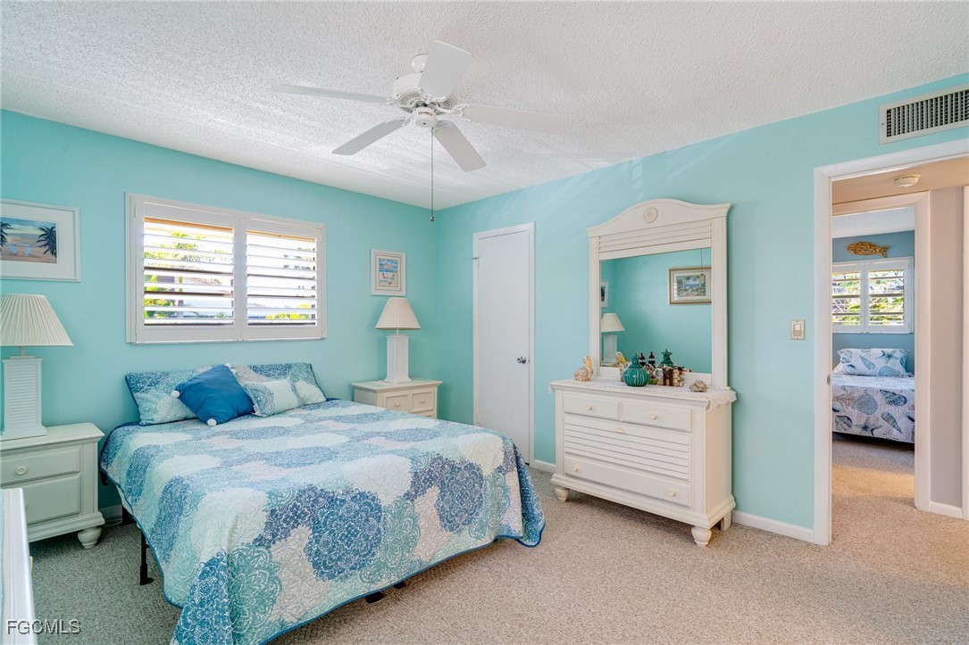 1549 Sandpiper Street, Unit 34 Naples, FL 34102 - Photo 7 of 15 a bedroom with a bed and a chandelier