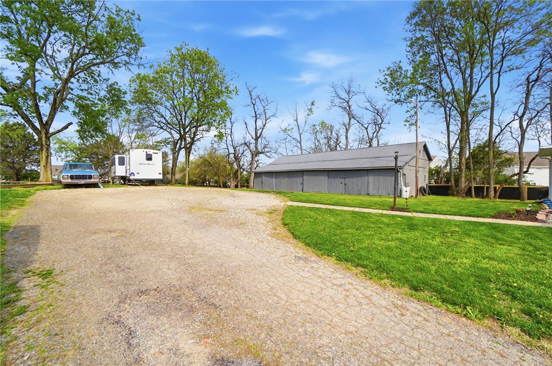 6155 North Union Road Clayton, OH 45315 - Photo 46 of 59 This expansive property features a versatile barn and a gravel driveway set amidst mature trees.