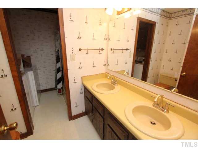 8616 Brandon Station Road Raleigh, NC 27613 - Photo 14 of 18 a bathroom with a sink a vanity and a mirror