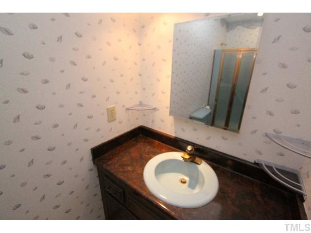 8616 Brandon Station Road Raleigh, NC 27613 - Photo 15 of 18 a bathroom with a sink and mirror
