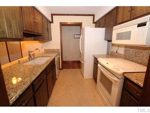 8616 Brandon Station Road Raleigh, NC 27613 - Photo 4 of 18 a kitchen with a sink stove and cabinets