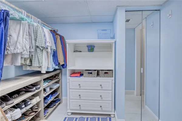 a view of walk in closet with clothes and shoes