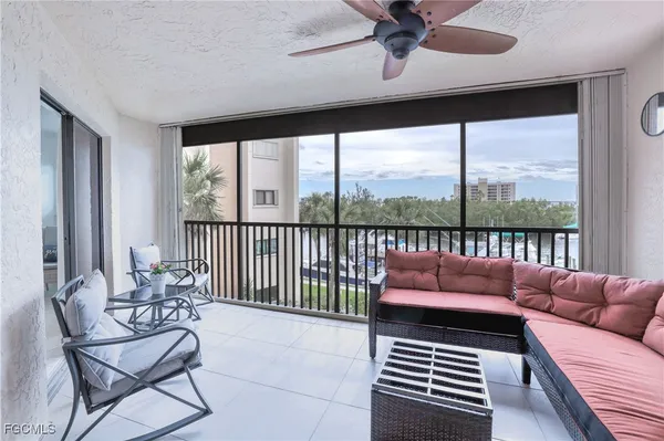 a balcony with furniture and a ceiling fan