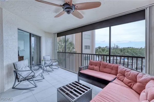 a balcony with furniture and a ceiling fan