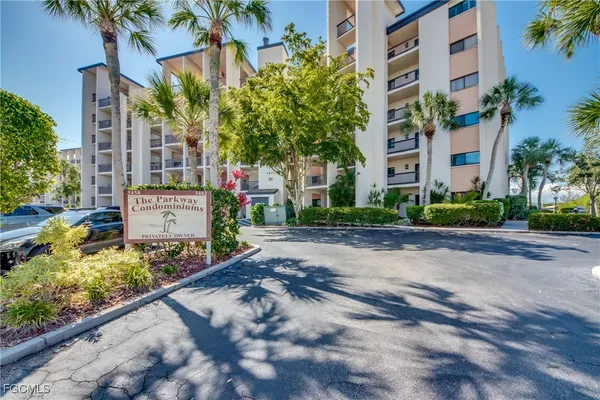 a view of a street with potted plants and large trees