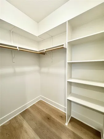 a view of a kitchen with kitchen island a sink wooden floor and a refrigerator