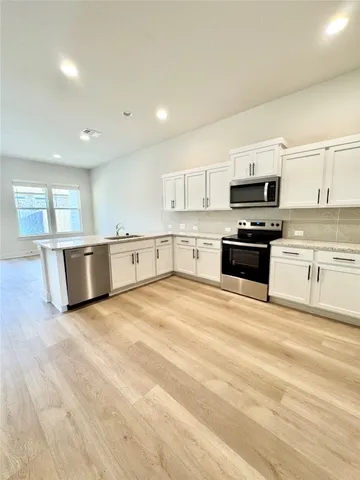a large kitchen with stainless steel appliances granite countertop a stove and a sink